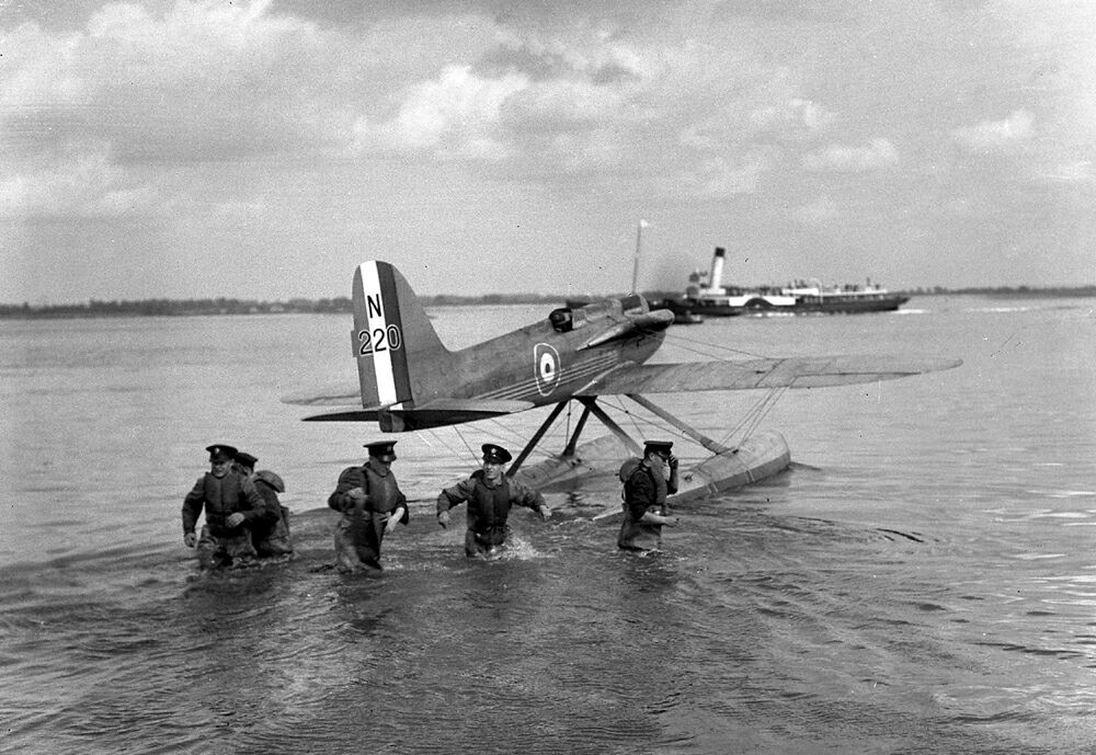 Insert image here: Supermarine S.6B moored at Calshot with cowlings open; engineers servicing coolant lines and the R engine boost plumbing.